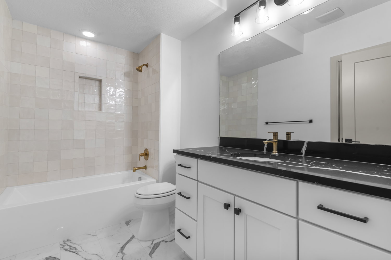 Bathroom with vanity, shower / tub combination, light marble finish flooring, and recessed lighting