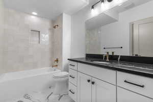 Bathroom with vanity, shower / tub combination, light marble finish flooring, and recessed lighting