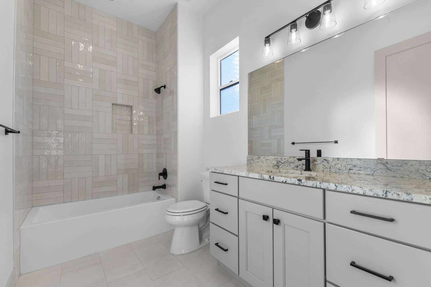 Bathroom featuring vanity, shower / tub combination, and light tile patterned floors