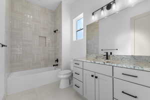 Bathroom featuring vanity, shower / tub combination, and light tile patterned floors