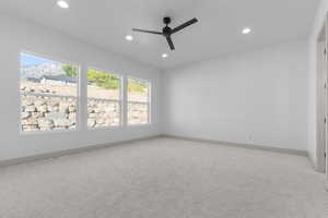 Spare room with light colored carpet, recessed lighting, a ceiling fan, and a mountain view