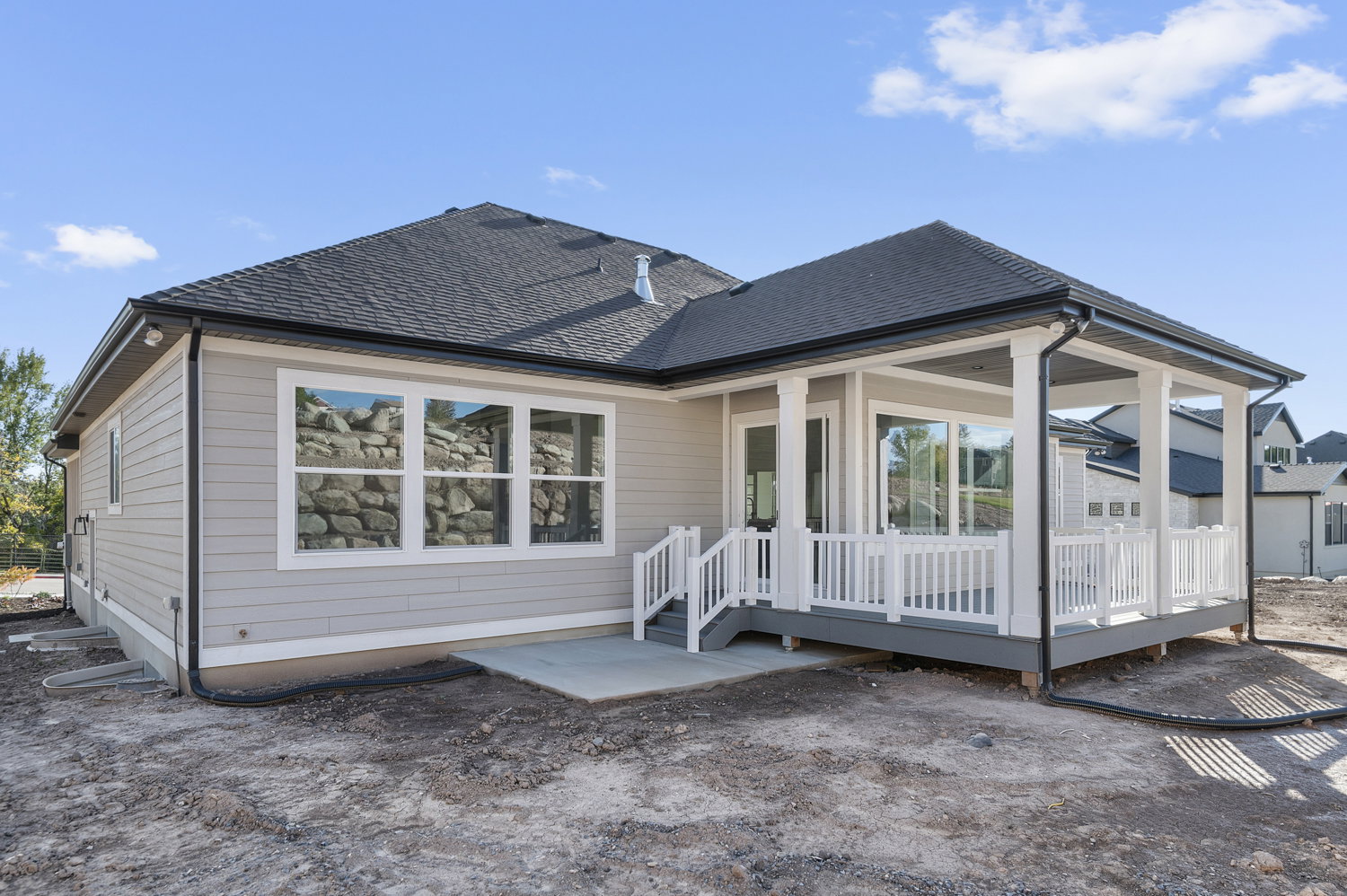 Rear view of property featuring roof with shingles, a patio area, and a deck
