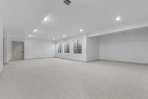 Finished below grade area featuring light carpet and recessed lighting