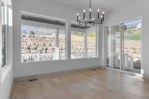 Unfurnished dining area with light wood-style floors and a chandelier
