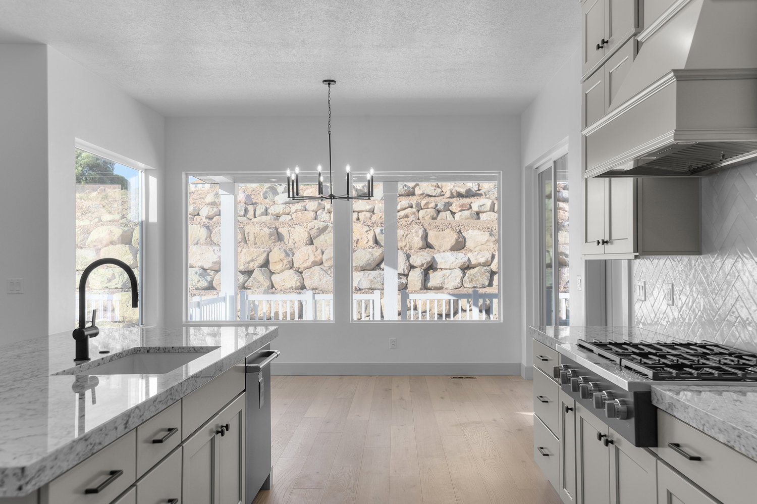 Kitchen featuring premium range hood, stainless steel appliances, plenty of natural light, a chandelier, and a textured ceiling