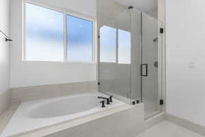 Full bath featuring a bath, a stall shower, and tile patterned flooring