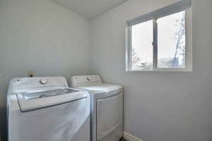 Laundry area with separate washer and dryer and baseboards