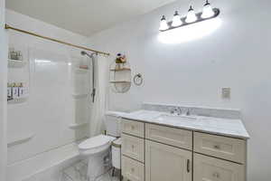 Full bath with a shower stall, vanity, and light marble finish flooring