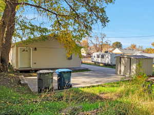 View of yard featuring a patio area, a storage unit, and a residential view