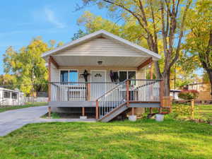 View of front of house with stairs and a wooden deck