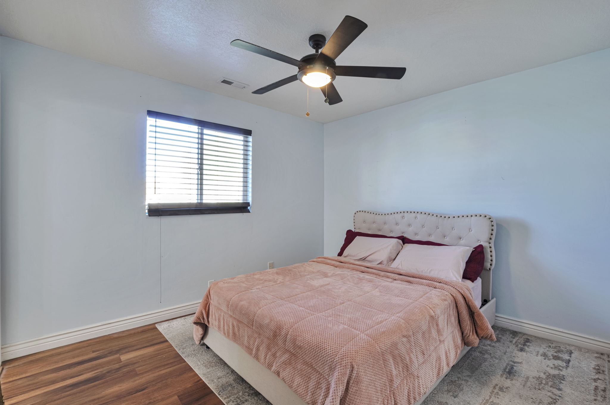 Bedroom featuring wood finished floors and a ceiling fan