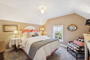 Bedroom featuring carpet floors and lofted ceiling