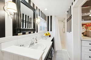 Full bath with vanity, a stall shower, tile patterned floors, tasteful backsplash, and tile walls