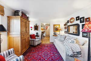 Living area with ornamental molding and dark wood finished floors