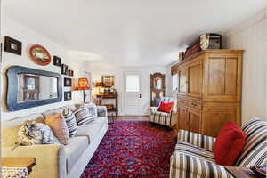 Living room featuring wood finished floors and crown molding