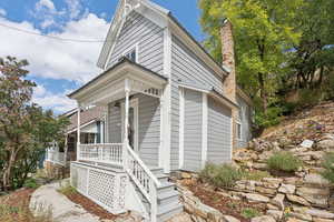 View of front facade with a chimney and covered porch