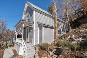 View of home's exterior with a metal roof, a porch, and a chimney
