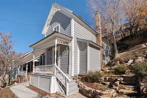 View of front of house featuring covered porch and a chimney