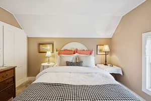 Bedroom featuring lofted ceiling and carpet