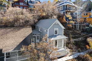 View of side of home featuring a metal roof and a porch