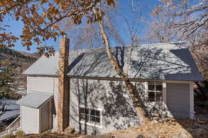 View of home's exterior featuring a metal roof and a chimney