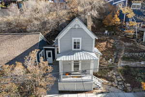 View of front of property featuring a chimney, a deck, and a metal roof