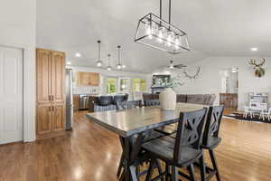 Dining room with lofted ceiling, light wood-style flooring, recessed lighting, and ceiling fan