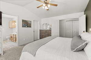 Bedroom with a closet, lofted ceiling, light carpet, a ceiling fan, and ensuite bathroom