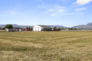 View of yard with a mountain view, a rural view, and an outbuilding