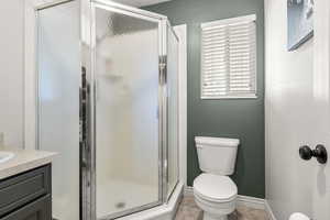 Bathroom with a stall shower, tile patterned floors, and vanity