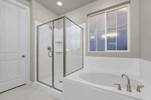 Full bathroom with a garden tub, a stall shower, and light marble finish flooring