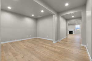 Spare room with recessed lighting, a fireplace, and light wood-type flooring