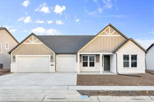 Craftsman inspired home with covered porch, board and batten siding, driveway, an attached garage, and brick siding