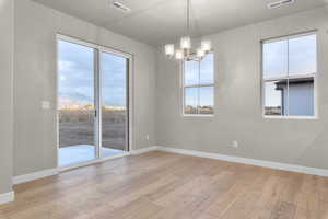 Empty room featuring a chandelier and light wood finished floors