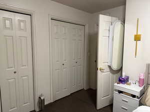 Bedroom featuring two closets and dark colored carpet