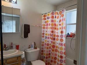 Bathroom featuring vanity and shower / bathtub combination with curtain