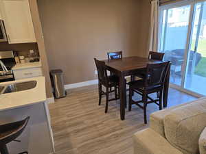 Dining area featuring light wood colored floor and sliding door access to back patio area