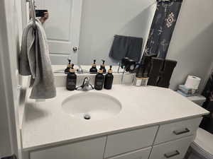 Bathroom with vanity and curtained shower