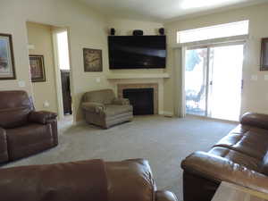 Carpeted living area featuring a fireplace