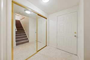 Entrance foyer with a textured ceiling, stairs, and light floors