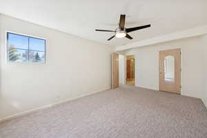Spare room featuring carpet floors and ceiling fan