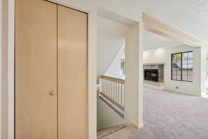 Hallway featuring carpet flooring, an upstairs landing, beam ceiling, and a textured ceiling