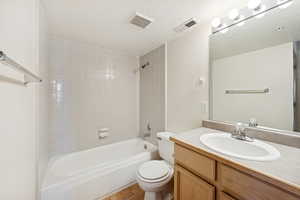 Full bath with shower / bath combination, vanity, and a textured ceiling