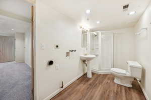 Full bath featuring recessed lighting, a shower stall, and wood finished floors