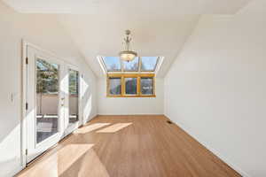 Additional living space with a skylight and light wood finished floors