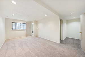 Spare room featuring recessed lighting and light carpet