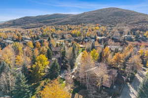 Aerial view of property and surrounding area featuring a mountain backdrop