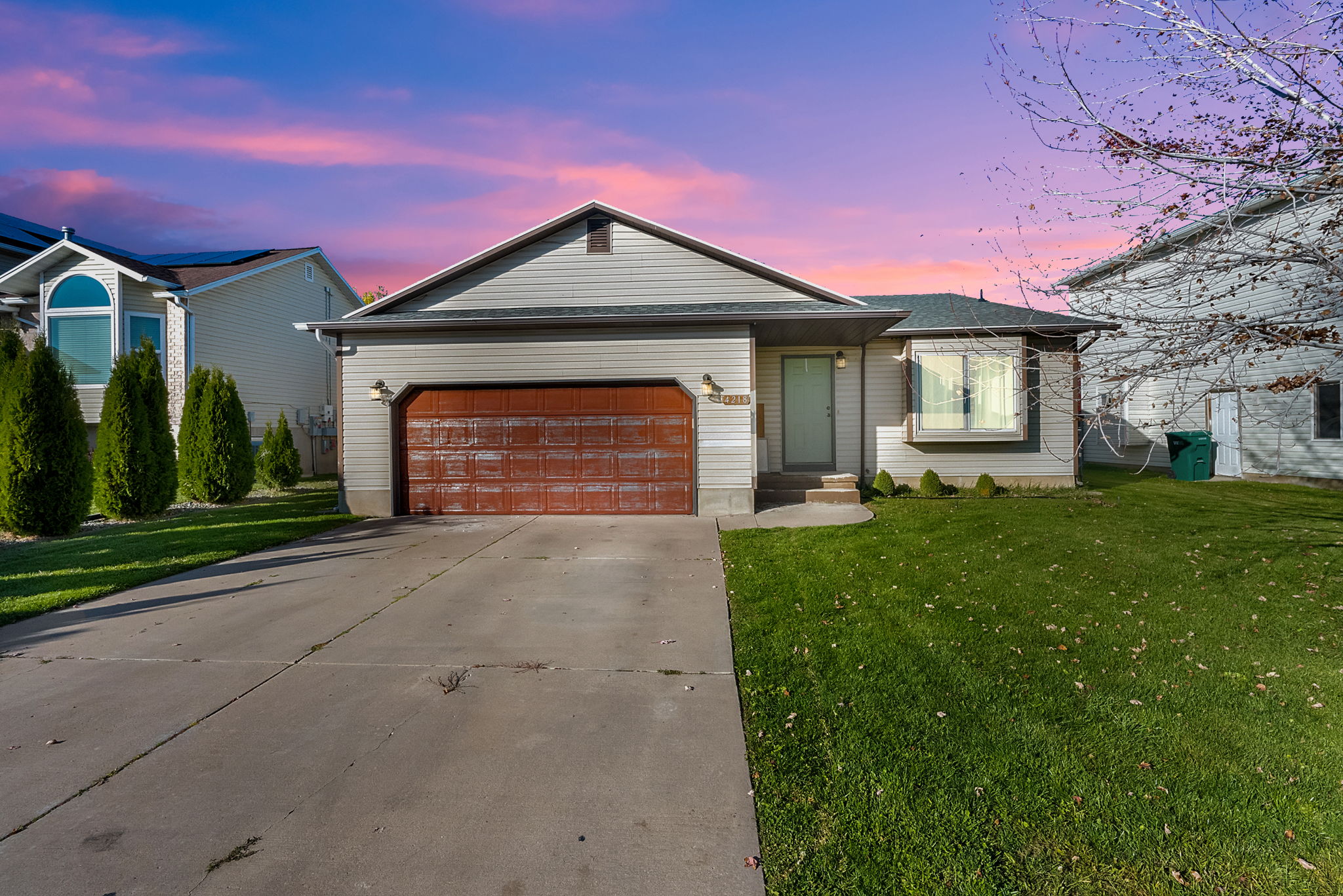 Multi level home with concrete driveway, a front yard, and an attached garage