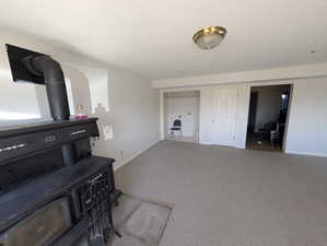 Carpeted bedroom with a textured ceiling and a wood stove