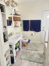 Bathroom featuring light tile patterned floors, ornamental molding, and a chandelier